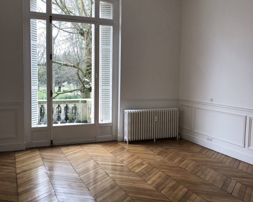 Chambre ou bureau avec grande fenêtre et parquet 