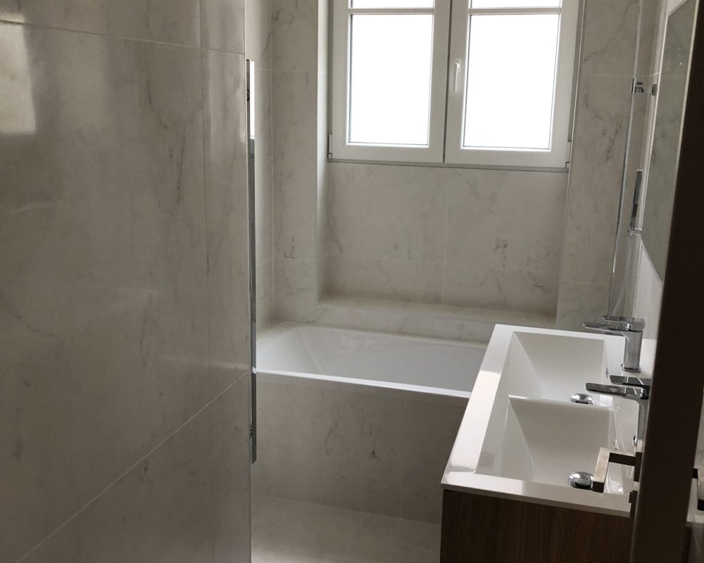 Salle de bains avec baignoire et carrelage mural brillant