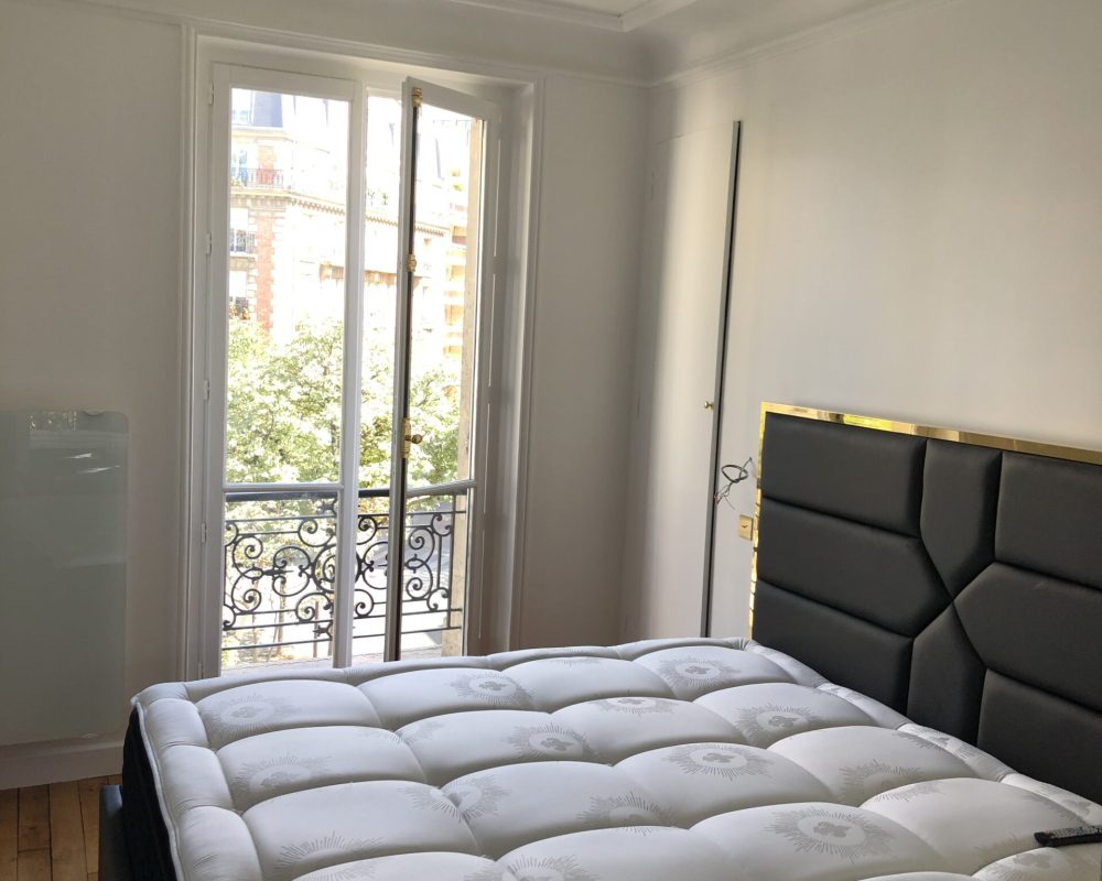 Chambre lumineuse avec grande fenêtre et literie haut de gamme