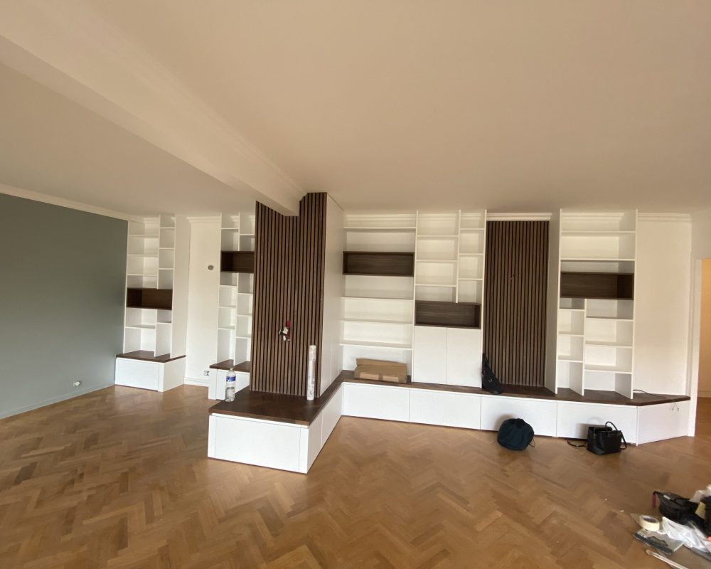 Séjour spacieux avec parquet chevron et rangements intégrés sur mesure