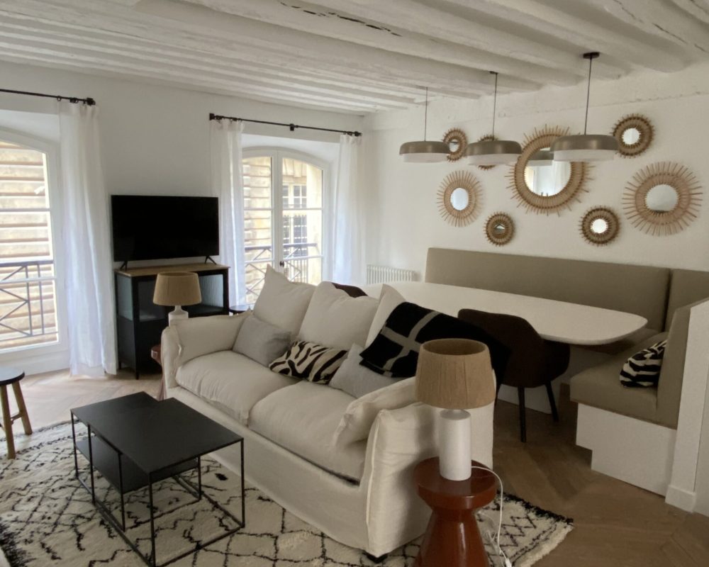 Salon chaleureux avec poutres apparentes et déco miroir