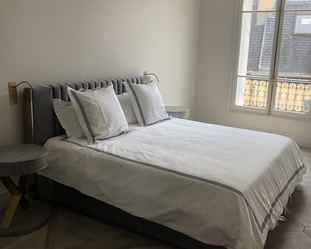 Chambre élégante avec lit double et tête de lit capitonnée 